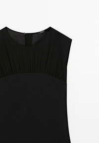 Schwarzes Kleid mit Rundhalsausschnitt, plissierten Details an der Brust und glatter Textur. Der Stoff wirkt weich und leicht.