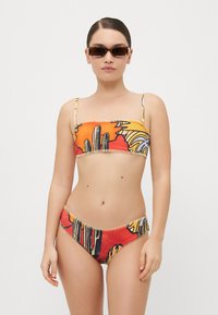 Dvojdielne bikiny s farebným kvetinovým a abstraktným vzorom, so priliehavým topom a nízkymi nohavičkami. Hladká tkanina s nastaviteľnými ramienkami.