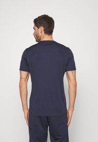 T-shirt a maniche corte blu navy in un tessuto morbido e leggero, con scollo rotondo e orlo leggermente curvo nella parte posteriore.