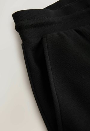 Fekete sportnadrág sima anyaggal, elasztikus derékrésszel és oldalzsebekkel, egyszerű dizájnnal és testhez simuló szabással.