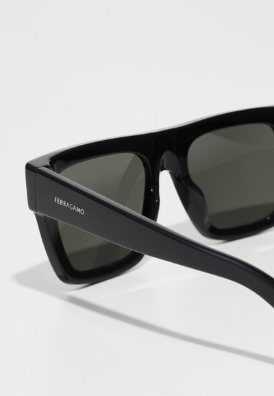 Black rectangular sunglasses with dark lenses and a sleek, glossy frame. Features the "Ferragamo" logo on the temple.