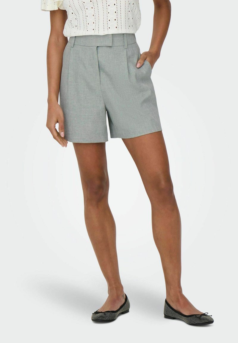 Grijze op maat gemaakte shorts met een hoge taille, voorplooien en zijzakken, gemaakt van lichtgewicht stof. Gecombineerd met zwarte ballerina's.