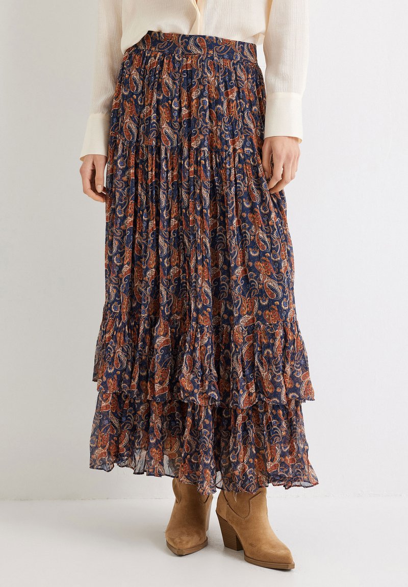 Falda maxi larga y escalonada en navy con un patrón de paisley en naranja y crema. Tela ligera y fluida con una cinturilla fruncida.