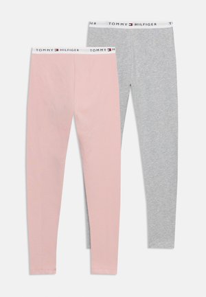 Dva páry legín Tommy Hilfiger, jeden růžový a jeden šedý, s bílými elastickými pasy s černými a červenými logy značky.