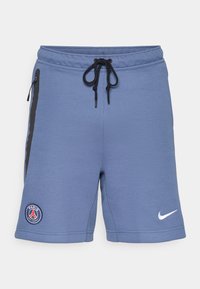 Mėlyni sportiniai šortai, pagaminti iš minkštos medžiagos, su juodais šoniniu užtrauktukais, raišteliu juosmenyje ir "Paris Saint-Germain" logotipu kairėje pusėje.