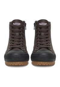 Brūnas augstas sporta kurpes ar melniem gumijas purngaliem, bieziem gumijas zolēm, melnām auklām, sānu rāvējslēdzējiem un "G-STAR ORIGINALS" etiķetēm uz mēlītēm.