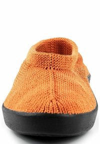 Pantofole lavorate a maglia arancioni con punta arrotondata, suola in gomma nera e colletto aderente. La texture è morbida; il design è semplice e senza cuciture.