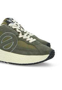 Baskets vert olive fabriquées en suede et en mailles, dotées d'une semelle intermédiaire blanche épaisse, d'une semelle extérieure texturée noire et d'un accent de logo sur le côté.