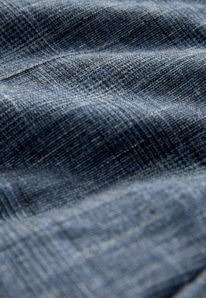 Tekstuuriga kangas sinise erinevates toonides, millel on kootud muster koos peente joonte ning pehme ja veidi reljeefse pinnaga.