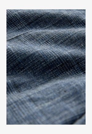 Tekstuuriga kangas sinise erinevates toonides, millel on kootud muster koos peente joonte ning pehme ja veidi reljeefse pinnaga.