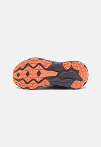Suola di scarpe da trail running nera con suola esterna in gomma arancione brillante. Presenta motivi di presa testurizzati e forme geometriche per un'aderenza ottimale.