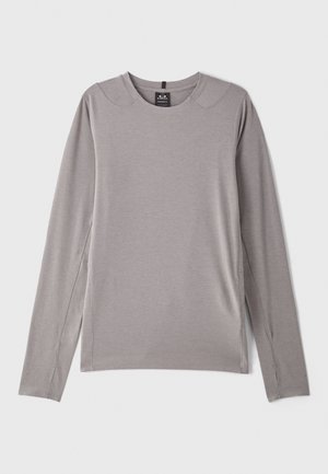 Grijze langemouwen shirt met een ronde halslijn, zijsplitten en een soepele, rekbare stof. Minimalistisch ontwerp zonder patronen of versieringen.