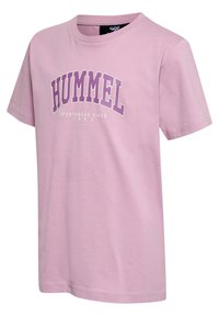 Lyserød T-shirt med korte ærmer lavet af bomuld, med ordet "HUMMEL" i fed lilla tekst og en rund halsudskæring.