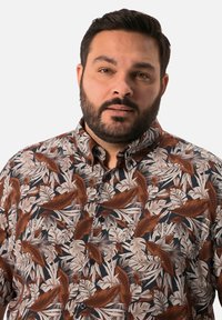 Camicia a maniche corte con motivo di foglie tropicali in crema, marrone e verde su sfondo nero; con bottoni e colletto.