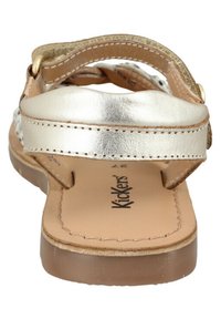 Guldmetallic sandaler med en tekstureret overdel, justerbar rem og en tan indersål. Sålen er klar med en glat overflade.