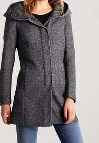 Cappotto grigio in lana con ampio colletto, chiusura con singolo bottone e vestibilità sartoriale. Le maniche lunghe e la superficie liscia arricchiscono il design.