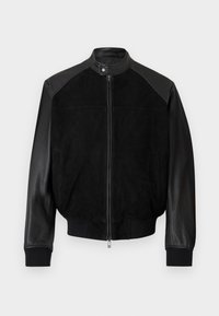 Μαύρο μπουφάν μπομπέρ με δερμάτινα μανίκια, σώμα από σουέντ, φερμουάρ μπροστά, γιακά με κουμπιά τύπου snap και ριμπ μανσέτες και τελείωμα.