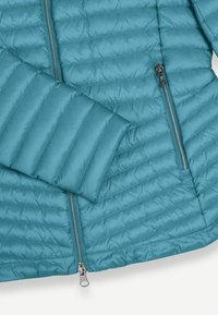 Türkisfarbene Pufferjacke mit horizontaler Steppoptik, seitlichen Reißverschlusstaschen und einem silbernen Reißverschluss. Glatte Oberfläche mit taillierter Passform.
