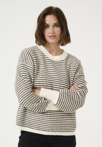 Pullover tricotat cu un model în dungi crem și maron, decolteu rotund și manșete cu nervuri. Materialul pare moale și are o greutate medie.