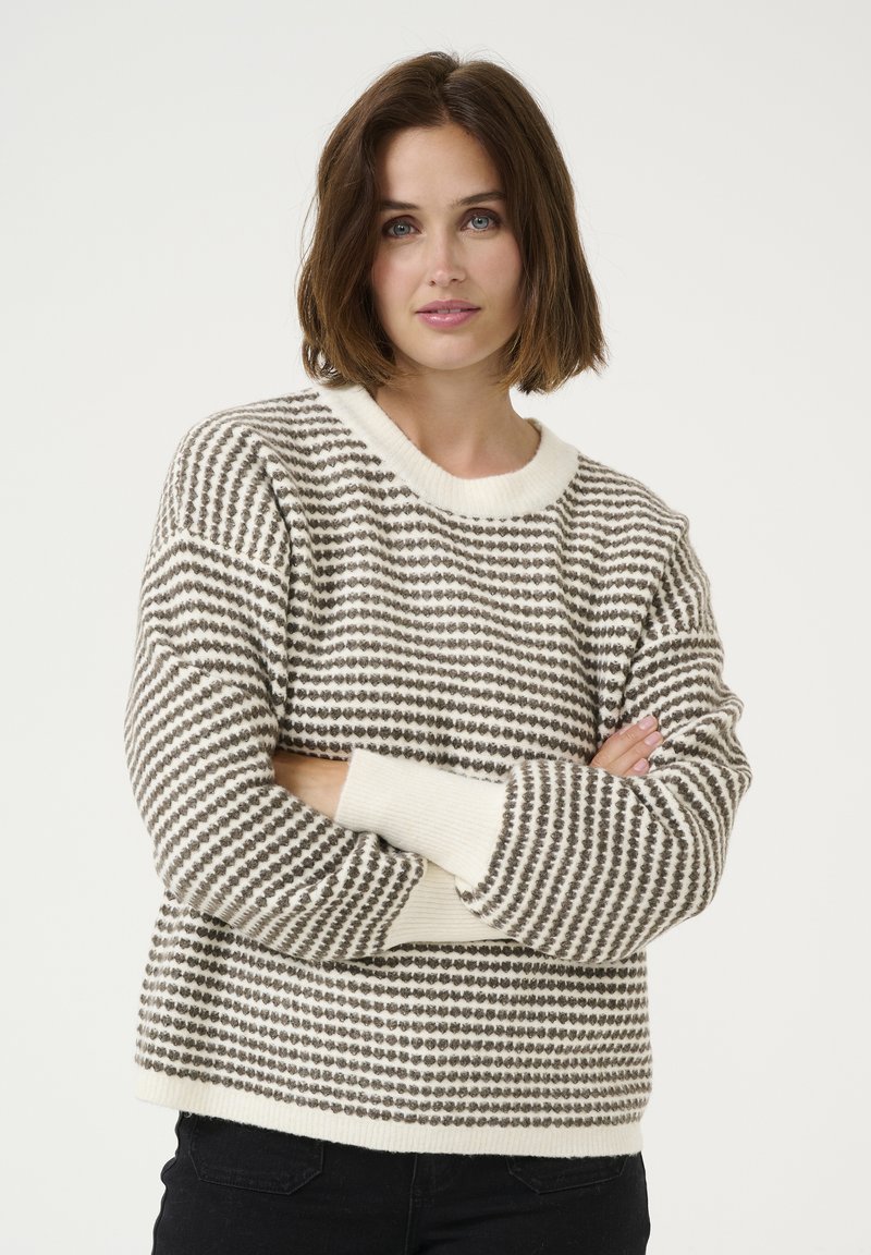 Knitted sweater with a cream and brown striped pattern, round neckline, and ribbed cuffs. Fabric appears soft and medium weight.