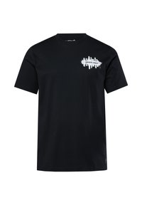 Camiseta de algodón negra de manga corta, con un diseño impreso en blanco que dice "CONCRETE JUNGLE" en el lado izquierdo del pecho. Corte casual y cuello redondo.