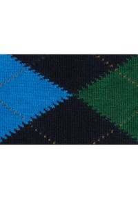 Tessuto a motivo argyle con grandi diamanti blu e verdi su uno sfondo scuro, con cuciture gialle in contrasto e una texture morbida.