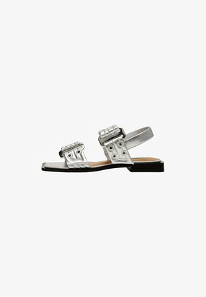 Zilveren metallic sandalen met twee gevlochten banden, ronde hardware accenten en een platte zool. Gladde textuur met een minimalistisch ontwerp.