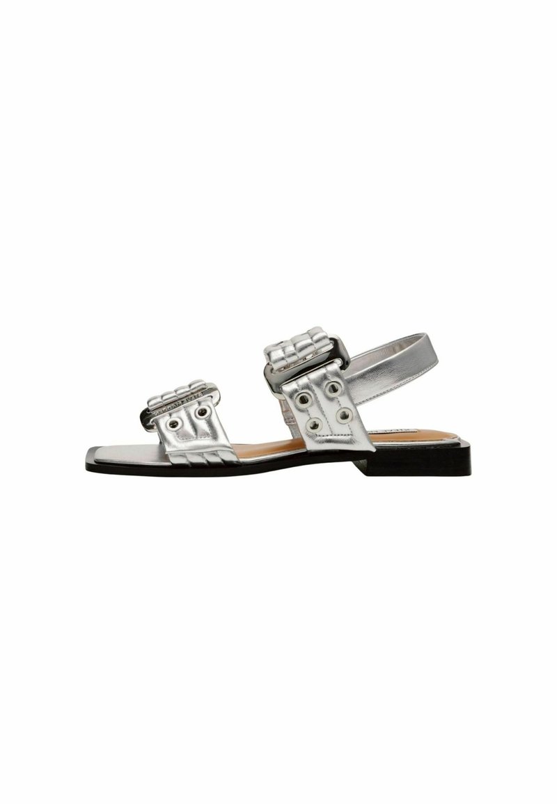 Silberne metallische Sandalen mit zwei geflochtenen Riemen, runden Hardware-Akzenten und einer flachen Sohle. Glatte Textur mit minimalistischem Design.