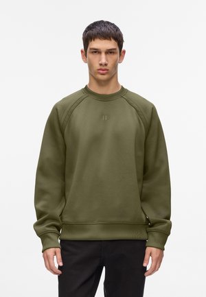 Sudadera de color verde oliva con puños y dobladillo acanalados. Presenta un escote redondo y un tejido texturizado con un pequeño logo en el pecho.