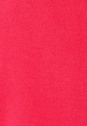 Gros plan sur un tissu tricoté rouge vif montrant une texture détaillée et un motif fin de tricot.