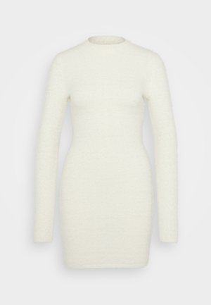 Ilgų rankovių suknelė, pagaminta iš minkštos, tekstūruotos baltos medžiagos; prigludusi siluetas su apvaliu iškirpimu ir lygiu paviršiumi, besitęsianti iki šlaunų vidurio.