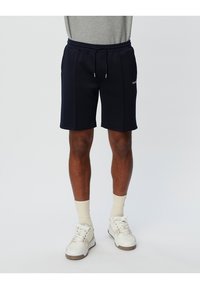 Navy blue athletic shorts with a drawstring waist and side pockets, featuring a subtle logo on the left thigh. Cotton blend material.