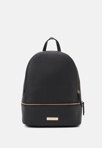 Black backpack made of textured material, featuring a rounded top, gold zipper, and a branded metal plate at the bottom.