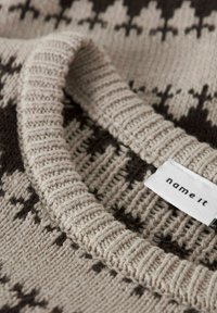Sweter dziany z beżowym i ciemnobrązowym geometrycznym wzorem. Żeberkowy dekolt i metka z napisem "name it" po boku.