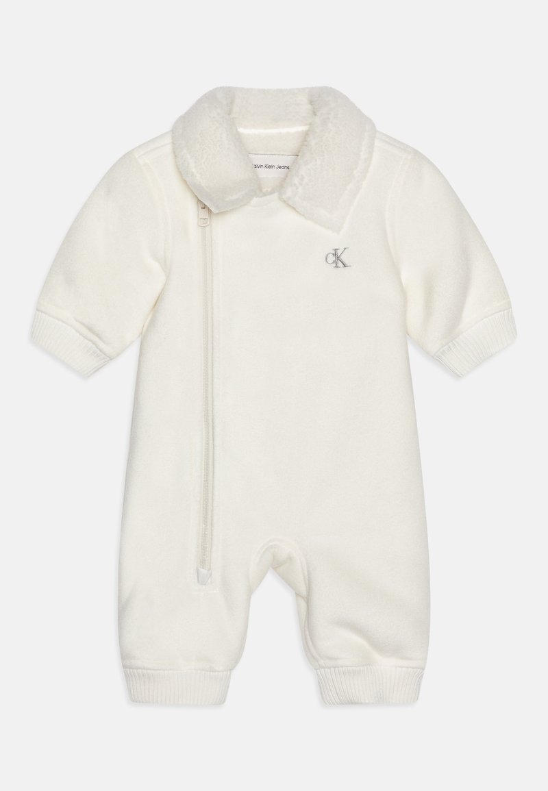 Tuta in pile bianco con colletto peluche, maniche corte, chiusura a zip e polsini a coste. Presenta un sottile logo CK sul petto.