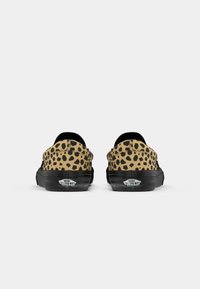 Par tenisica nizakog kroja Vans, s bež i crnim uzorkom leopardove kože i crnim gumenim potplatima, prikazano sa stražnje strane.
