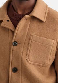 Bruin wollen blend jack met een knoopsluiting, een borstzak en een gestructureerde afwerking met een gelaagd gebreid kraag.