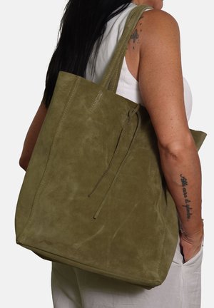 Olivgrüne Wildleder-Tote mit zwei Griffen, einer sanften Textur und einem Kordelzugverschluss. Große, quadratische Form mit minimalen Nähdetails.