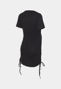 Vestido de tecido elástico preto com mangas curtas, laterais drapeadas e laços ajustáveis na barra para um melhor ajuste. Textura suave, comprimento até a metade da coxa.