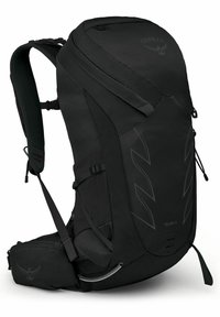 Zaino nero con un design snello, caratterizzato da una superficie testurizzata, spallacci regolabili e un compartimento centrale con accesso tramite zip.