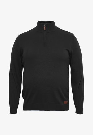 Musthave mustripsiga musta kõrge kaelusega kampsun, millel on poole tõmblukuga sulgemine ja ribakäised. Hemmis on väike pruuni nahast logo silt.