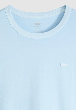 Jasnoniebieska koszulka z okrągłym dekoltem i małym białym logo Levi's po lewej stronie klatki piersiowej, wykonana z miękkiej bawełnianej tkaniny.