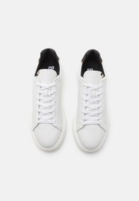 Ein Paar weiße Low-Top-Sneaker mit weißen Schnürsenkeln, schwarzem Innenfutter und dem geprägten "BOSS"-Logo auf der Zunge.