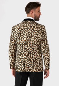 Blazer con stampa leopardata in beige, caratterizzato da macchie nere e arancioni, con colletto a contrasto nero, vestibilità su misura e spacco singolo sul retro.