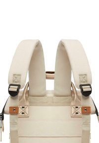 Beige Rucksack mit gepolsterten Trägern, verstellbaren Schnallen, verstärkten Nähten und Lederakzenten. Glattes, strukturiertes Gewebe mit minimalistischem Design.