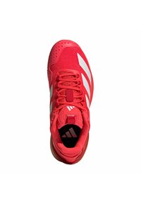 Scarpa sportiva rossa con tomaia in tessuto, strisce bianche, collare imbottito e dettaglio forato sulla punta. Presenta lacci e suola in gomma.