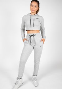 Light grey cropped hoodie with black drawstrings, paired with matching joggers featuring an elastic waistband and side pockets.
