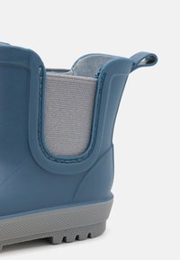 Mėlyna guminė avalynė su tekstūruota pilka medžiaga, suapvalintu viršumi, užtrauktuku ir pilku padu, turinčiu sukibimo griovelius.