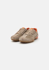 Lys brun sued og mesh treningssko med oransje detaljer, teksturert overflate og gummisåle. Sikker snøring design.