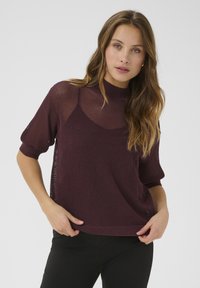 Burgundy knit top with a mesh texture, short sleeves, and a high neckline. The fabric is lightweight and has an open weave design.